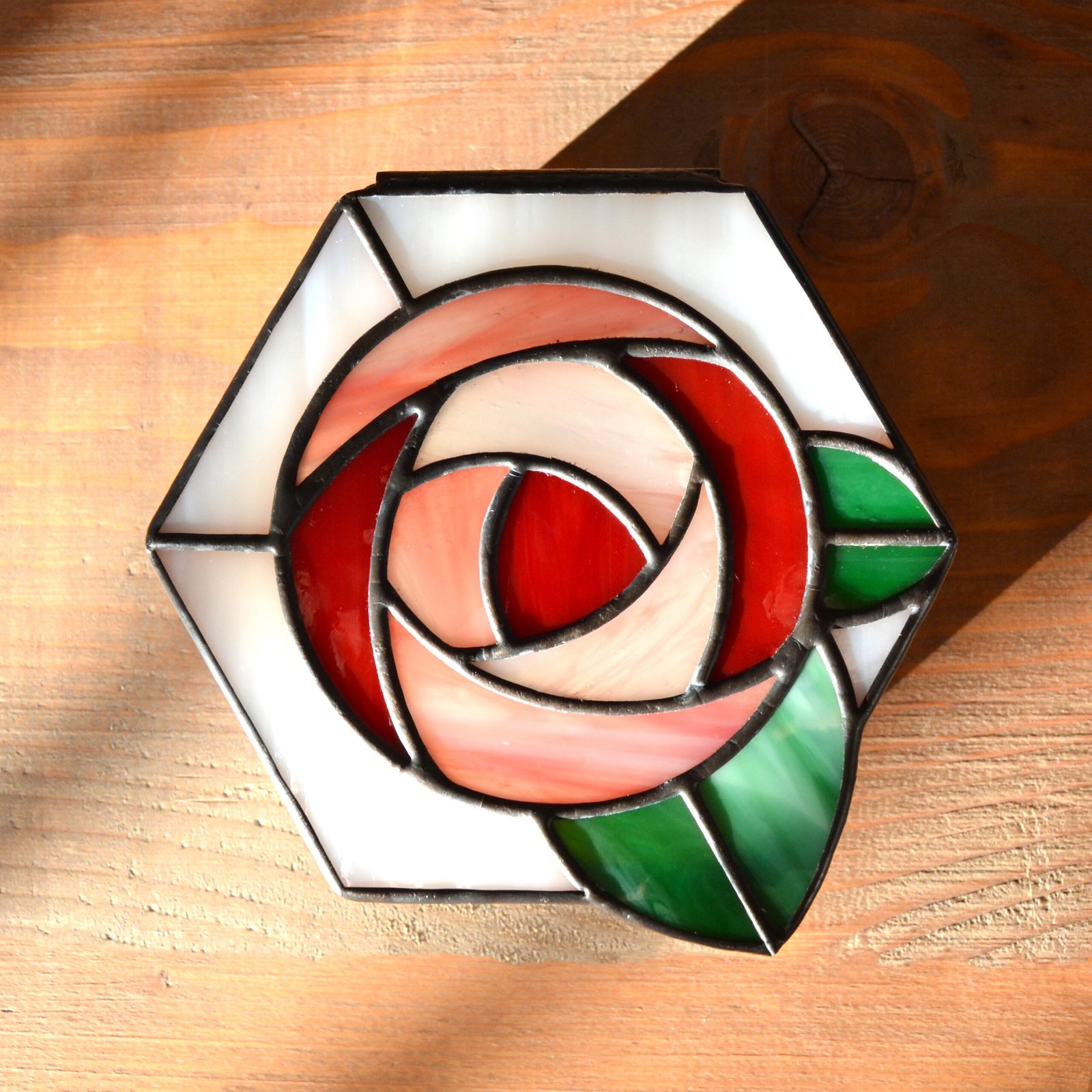 Una caja de vidrio meticulosamente tallada con detalles intrincados que representan una exquisita flor en pleno florecimiento, capturando la belleza y la fragilidad de la naturaleza en una obra de arte transparente.