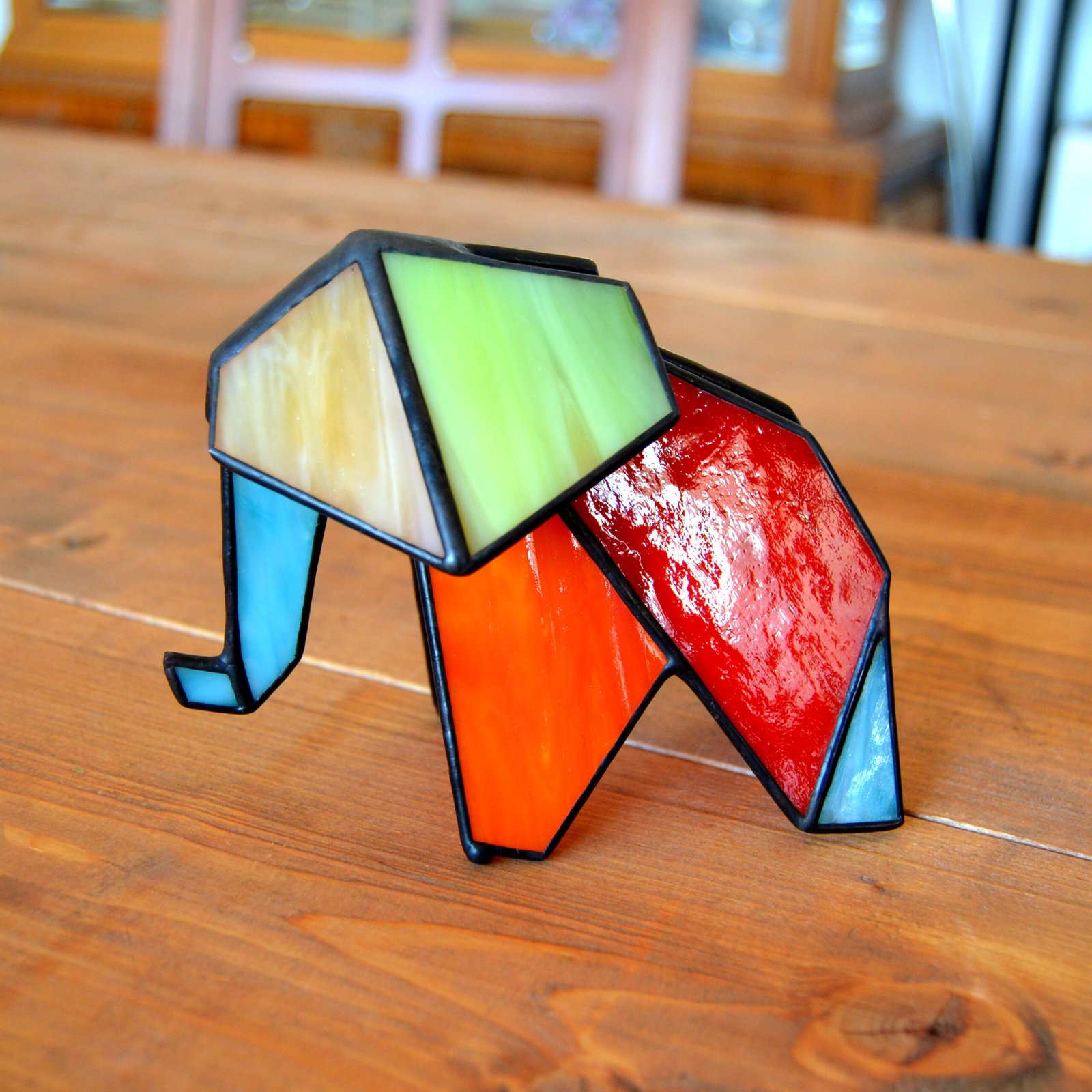 Figurita de elefante en vitral, con colores brillantes y vivos.