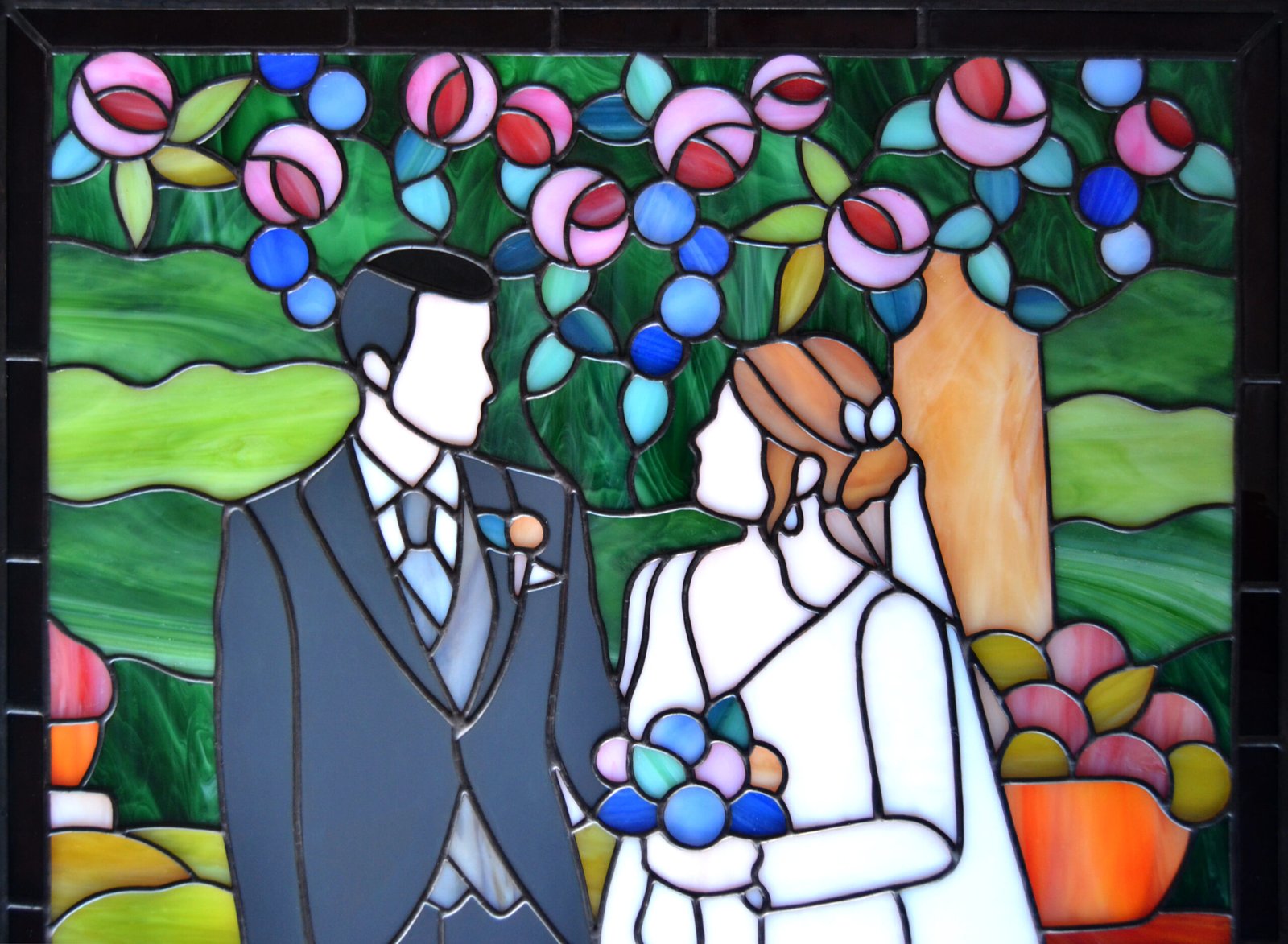 Un vitral artísticamente elaborado que representa a dos personas en su día de boda, con detalles meticulosos que capturan la emoción y la belleza del momento, mientras la luz del sol ilumina los colores vivos y crea un ambiente lleno de amor y alegría.