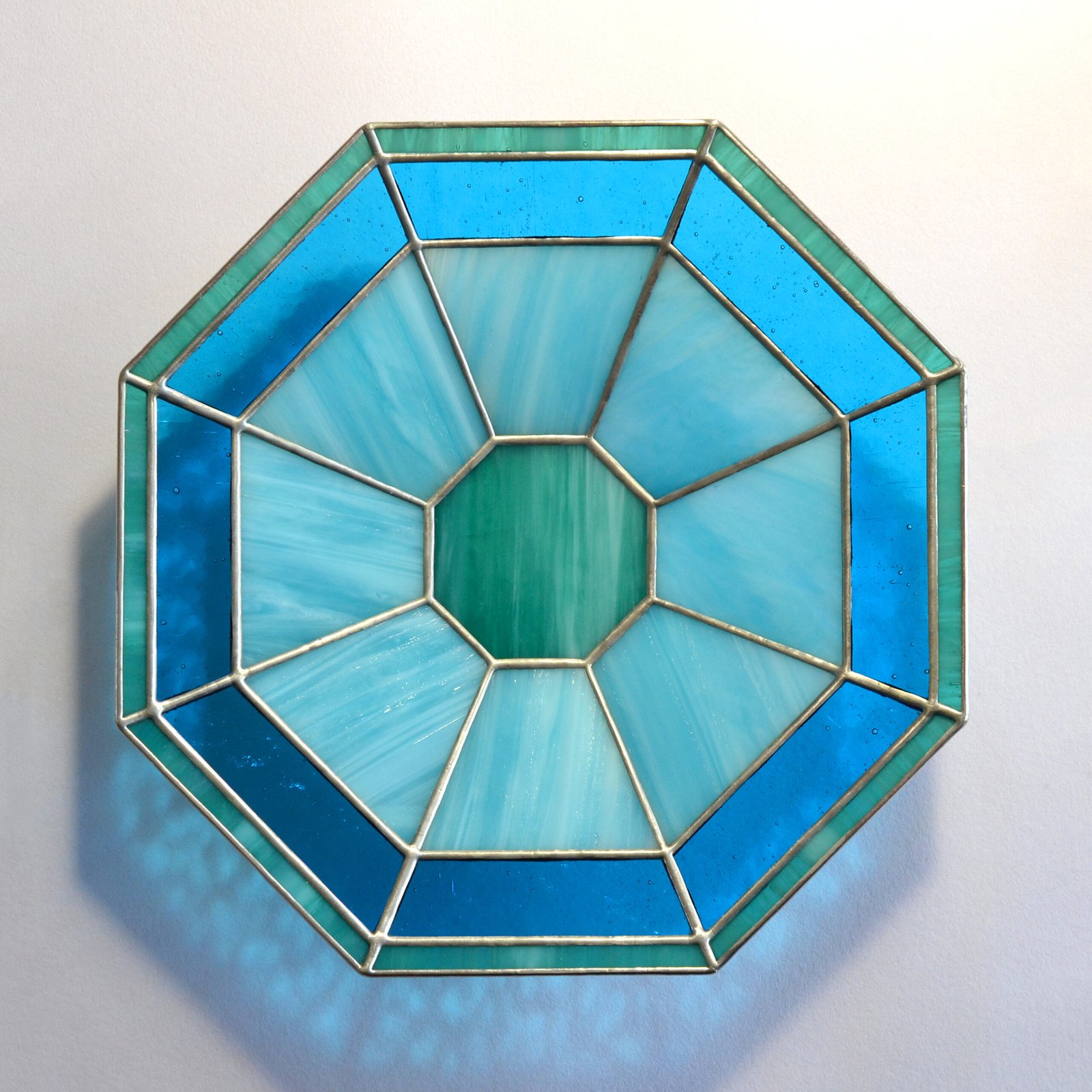 Imagen de una obra de vidrio soplado con formas orgánicas y colores vibrantes, emanando energía y vitalidad creativa.