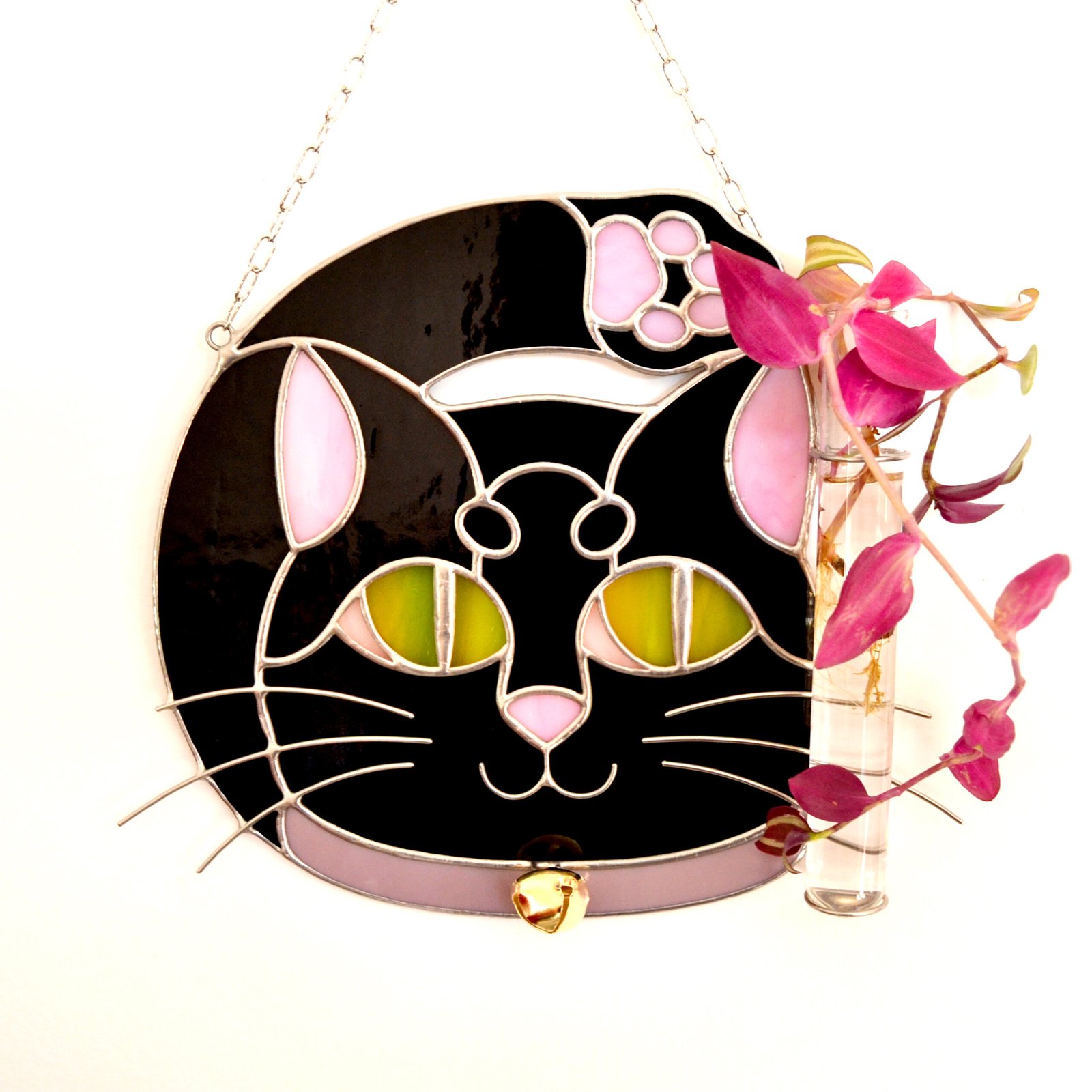 Un vitral que retrata a un elegante gato, con sus ojos curiosos y su pelaje suave y brillante, capturando la gracia y la serenidad de este majestuoso animal mientras la luz del sol filtra a través de los colores vibrantes y crea un efecto cautivador en cualquier espacio.