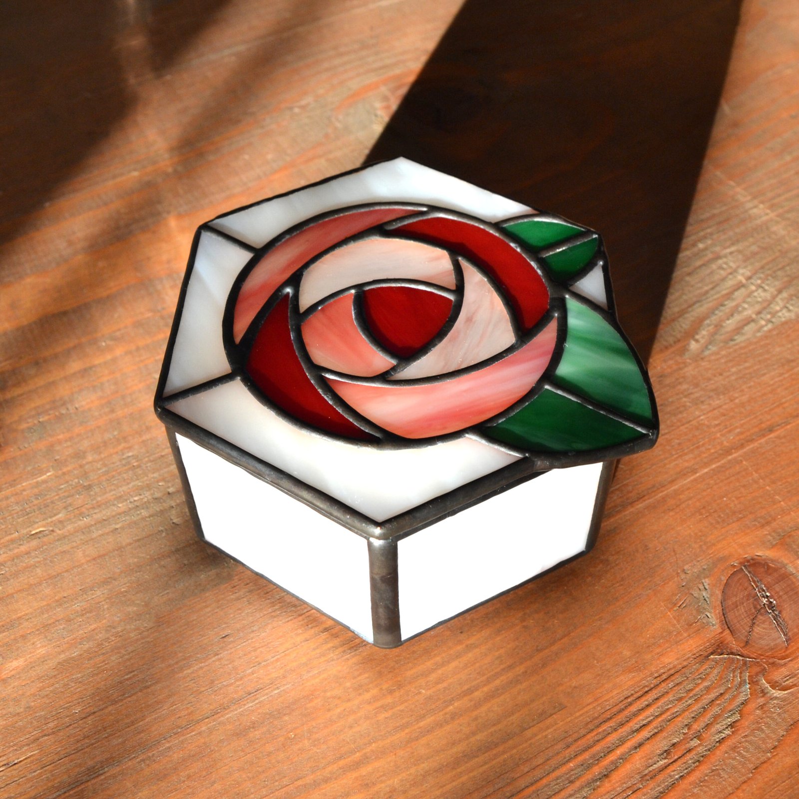 Una caja de vidrio meticulosamente tallada con detalles intrincados que representan una exquisita flor en pleno florecimiento, capturando la belleza y la fragilidad de la naturaleza en una obra de arte transparente.