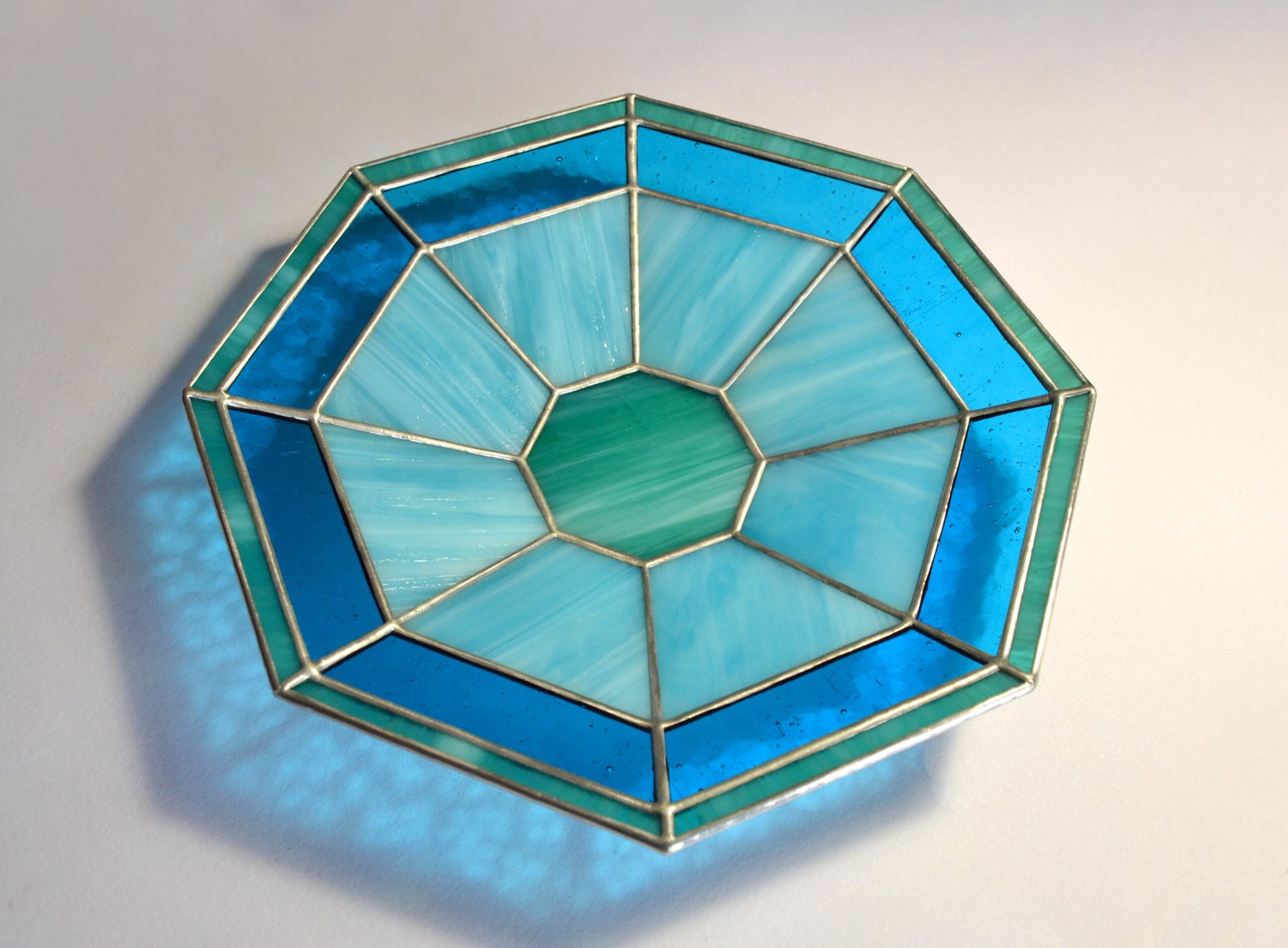 Imagen de una obra de vidrio soplado con formas orgánicas y colores vibrantes, emanando energía y vitalidad creativa.