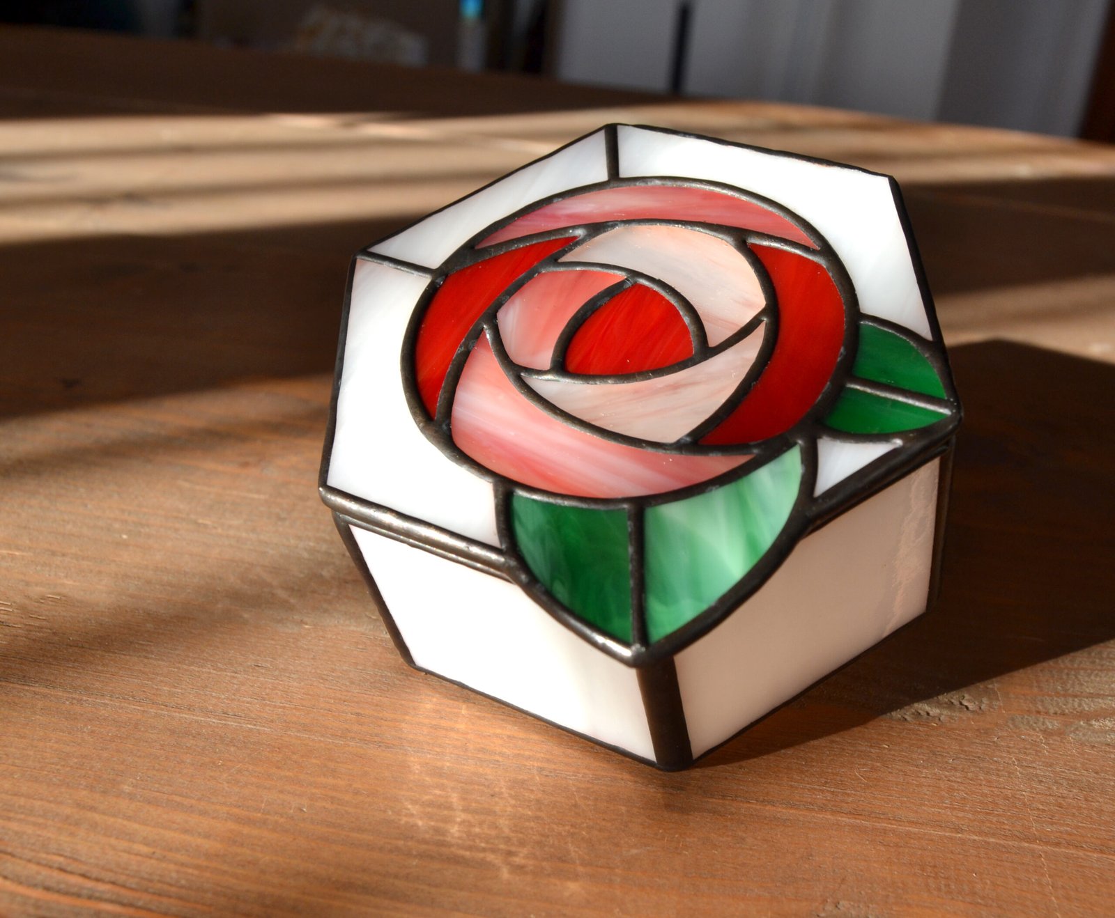 Una caja de vidrio meticulosamente tallada con detalles intrincados que representan una exquisita flor en pleno florecimiento, capturando la belleza y la fragilidad de la naturaleza en una obra de arte transparente.