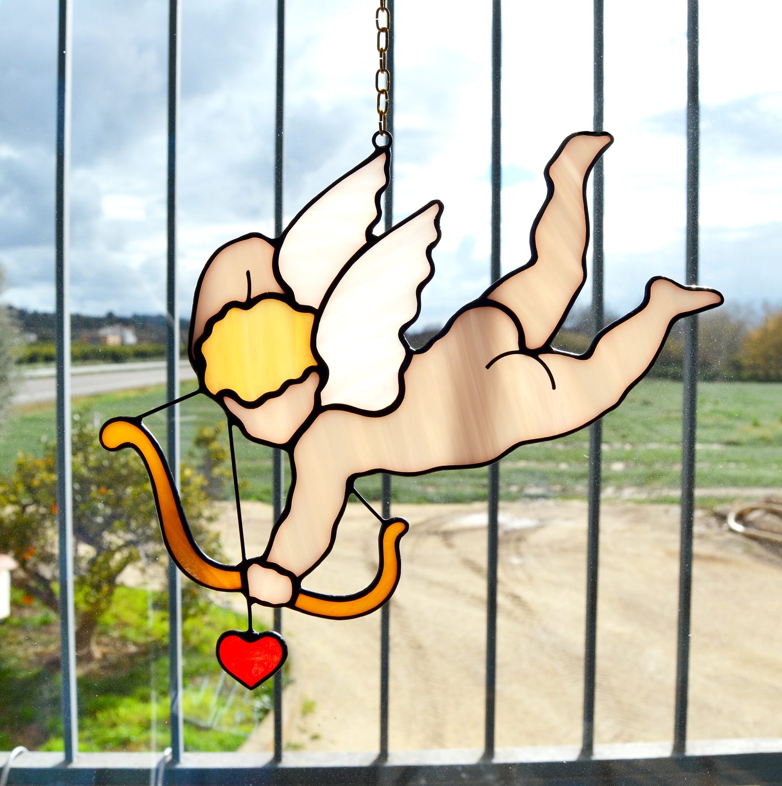 Cupido en vitral, con colores brillantes y vivos.