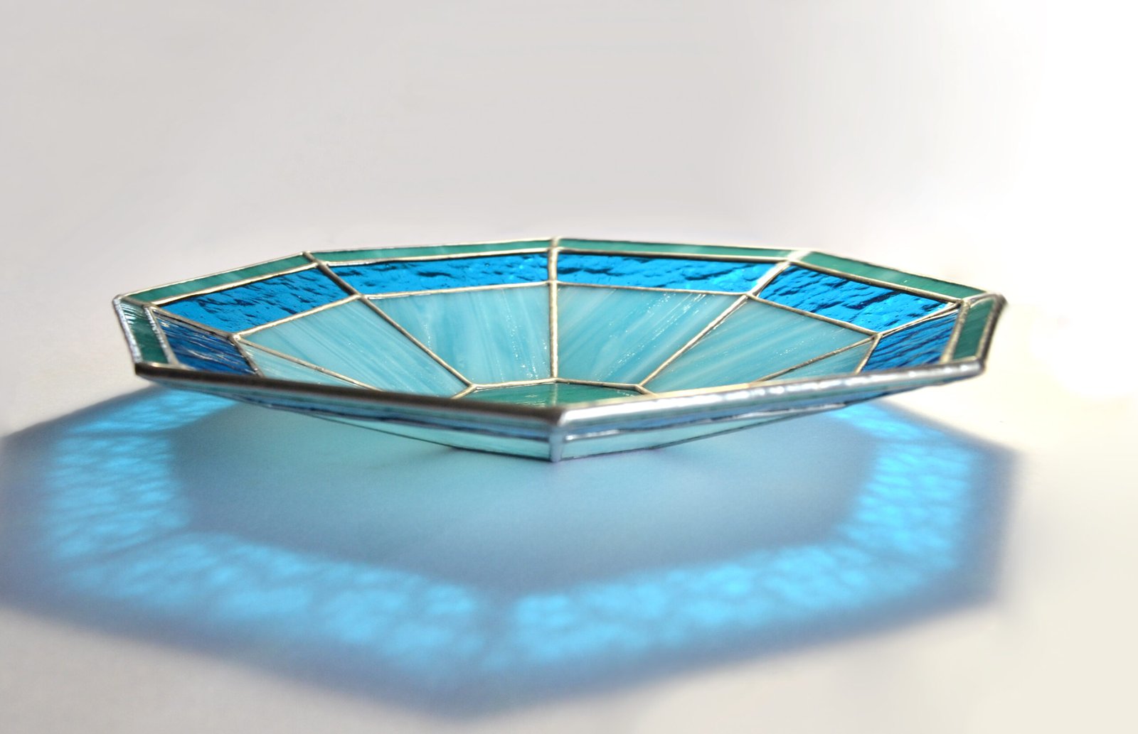 Imagen de una obra de vidrio soplado con formas orgánicas y colores vibrantes, emanando energía y vitalidad creativa.