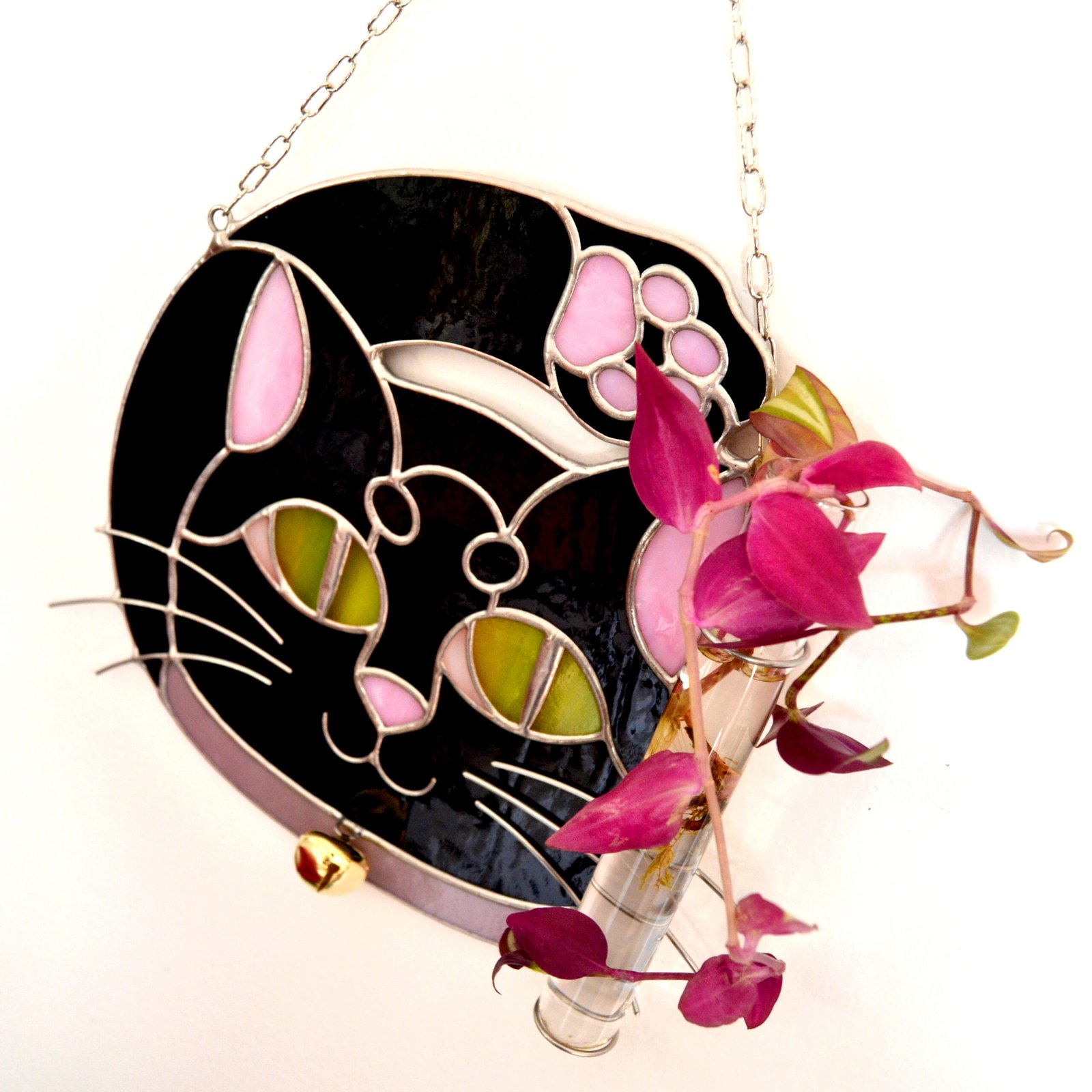 Un vitral que retrata a un elegante gato, con sus ojos curiosos y su pelaje suave y brillante, capturando la gracia y la serenidad de este majestuoso animal mientras la luz del sol filtra a través de los colores vibrantes y crea un efecto cautivador en cualquier espacio.