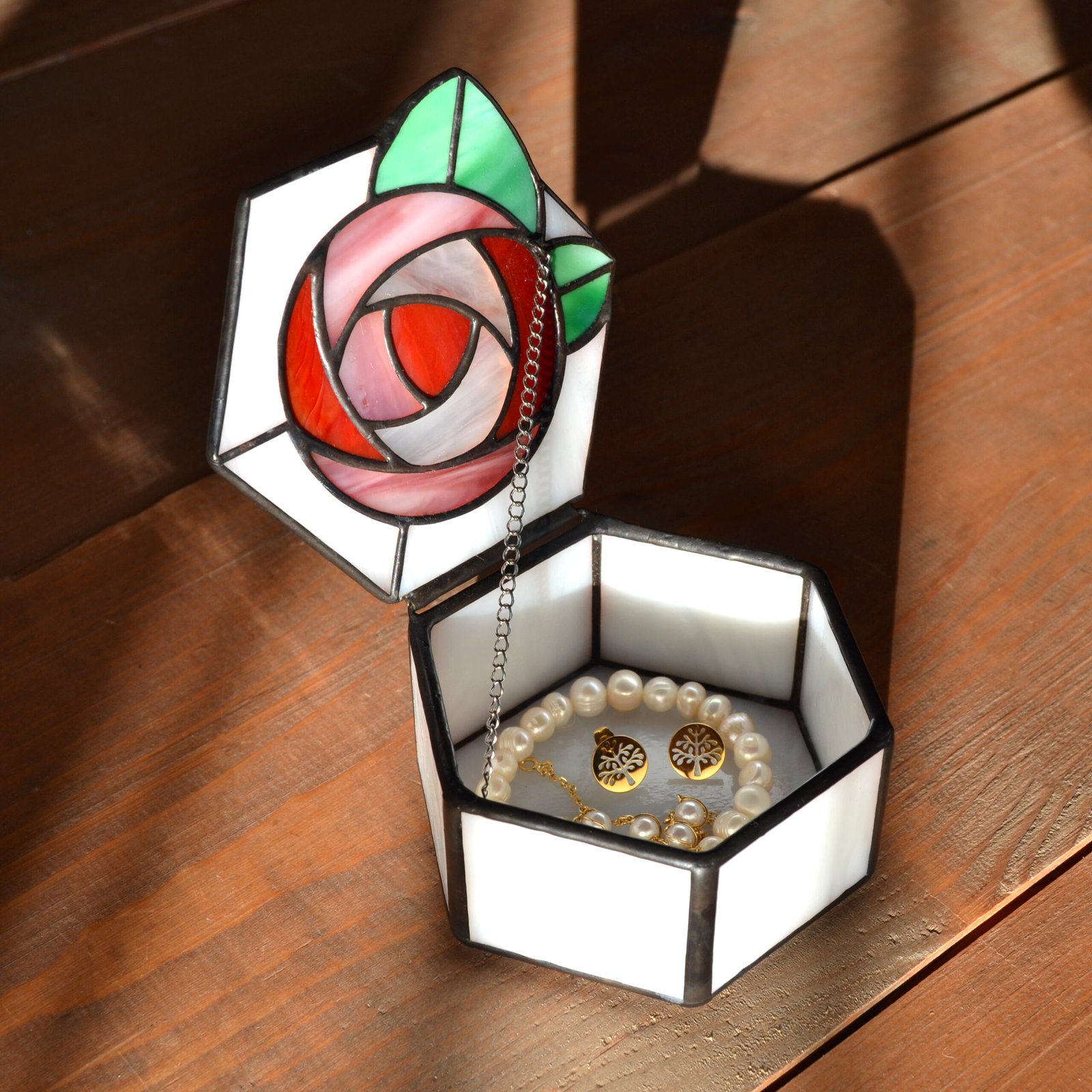 Una caja de vidrio meticulosamente tallada con detalles intrincados que representan una exquisita flor en pleno florecimiento, capturando la belleza y la fragilidad de la naturaleza en una obra de arte transparente.