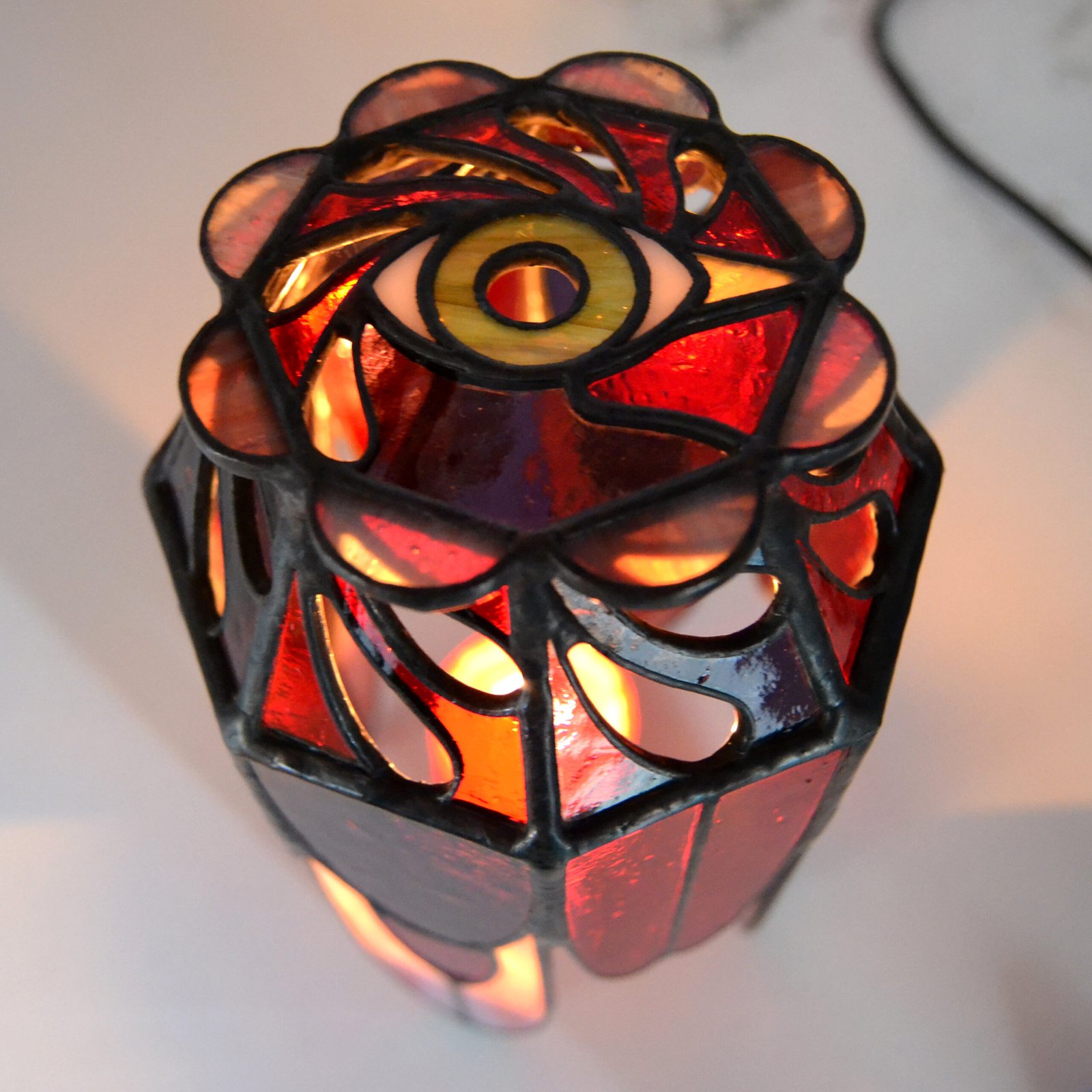 Un bote de vidrio transparente diseñado para sostener una vela, con una estructura resistente y una superficie lisa que permite que la luz de la llama brille con claridad, creando una atmósfera cálida y acogedora en cualquier ambiente.