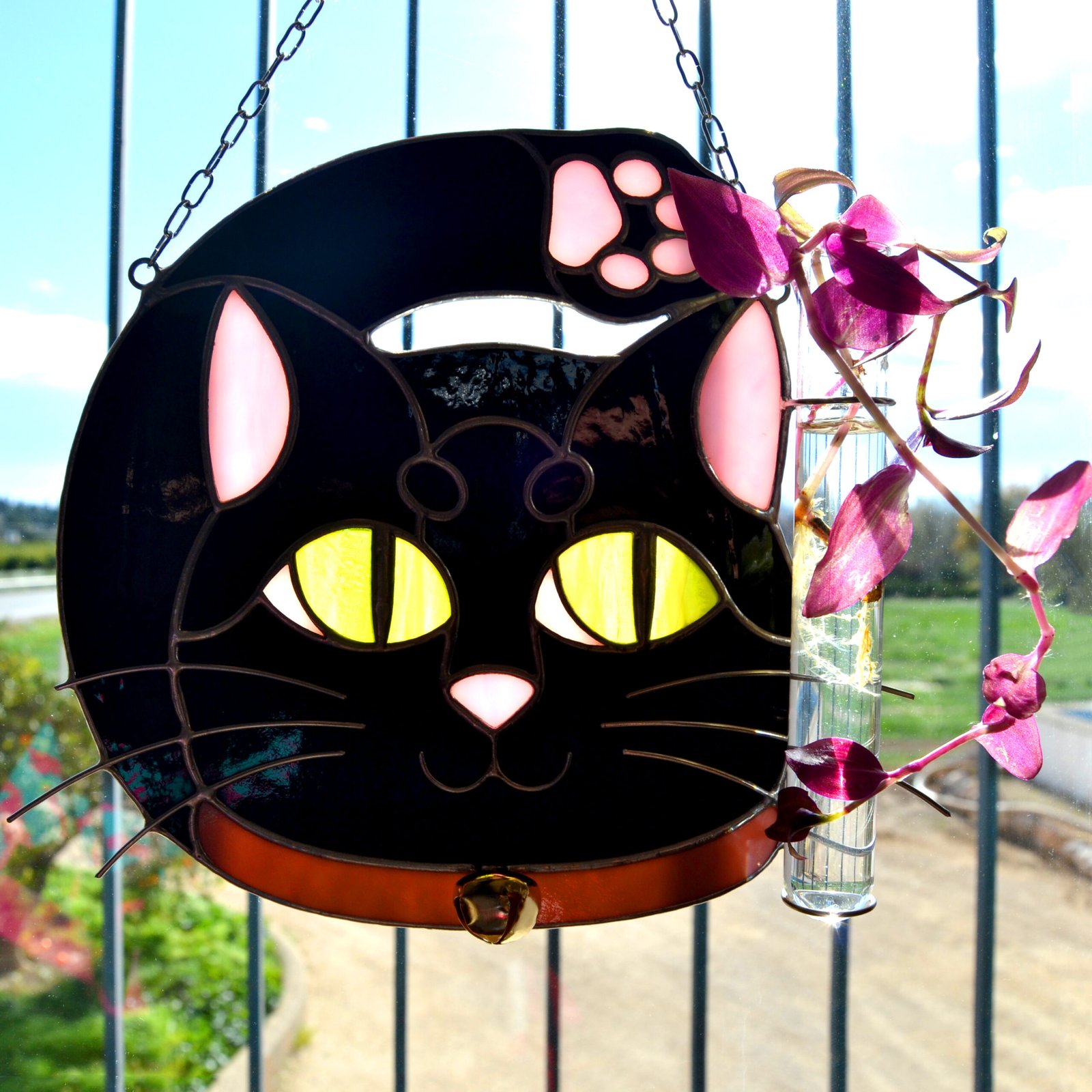 Un vitral que retrata a un elegante gato, con sus ojos curiosos y su pelaje suave y brillante, capturando la gracia y la serenidad de este majestuoso animal mientras la luz del sol filtra a través de los colores vibrantes y crea un efecto cautivador en cualquier espacio.