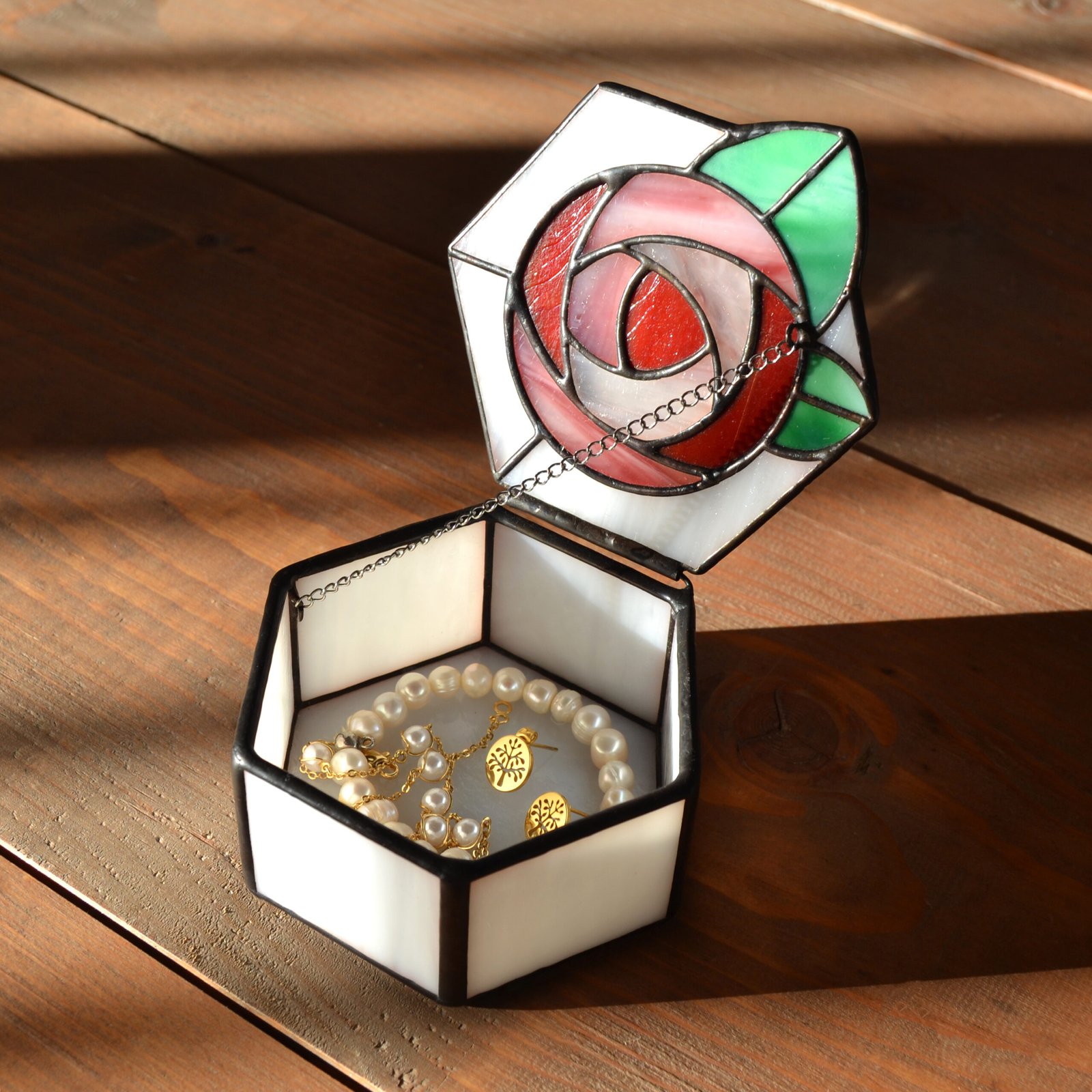 Una caja de vidrio meticulosamente tallada con detalles intrincados que representan una exquisita flor en pleno florecimiento, capturando la belleza y la fragilidad de la naturaleza en una obra de arte transparente.