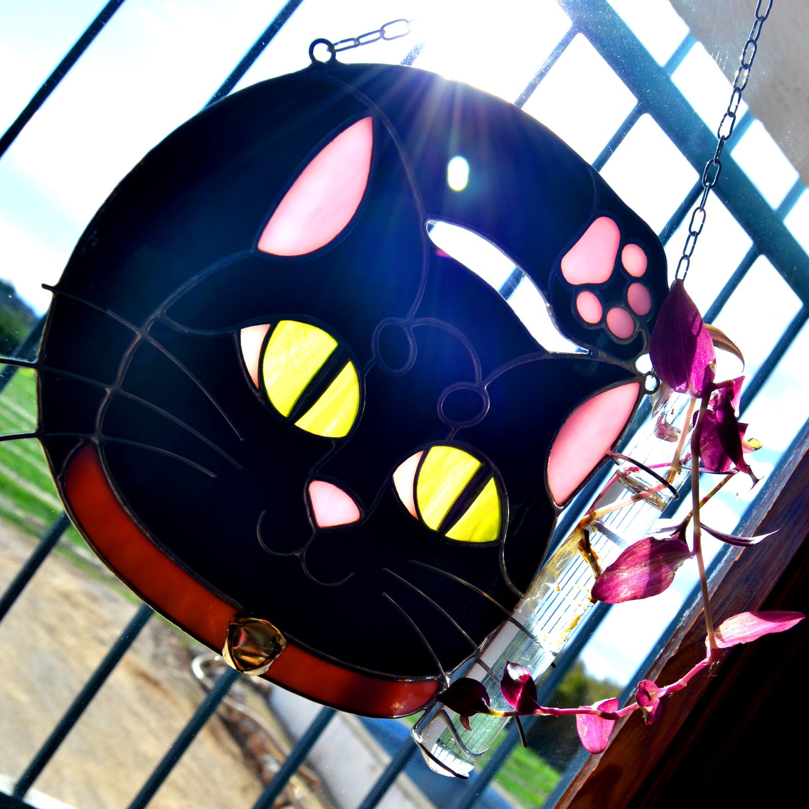 Un vitral que retrata a un elegante gato, con sus ojos curiosos y su pelaje suave y brillante, capturando la gracia y la serenidad de este majestuoso animal mientras la luz del sol filtra a través de los colores vibrantes y crea un efecto cautivador en cualquier espacio.