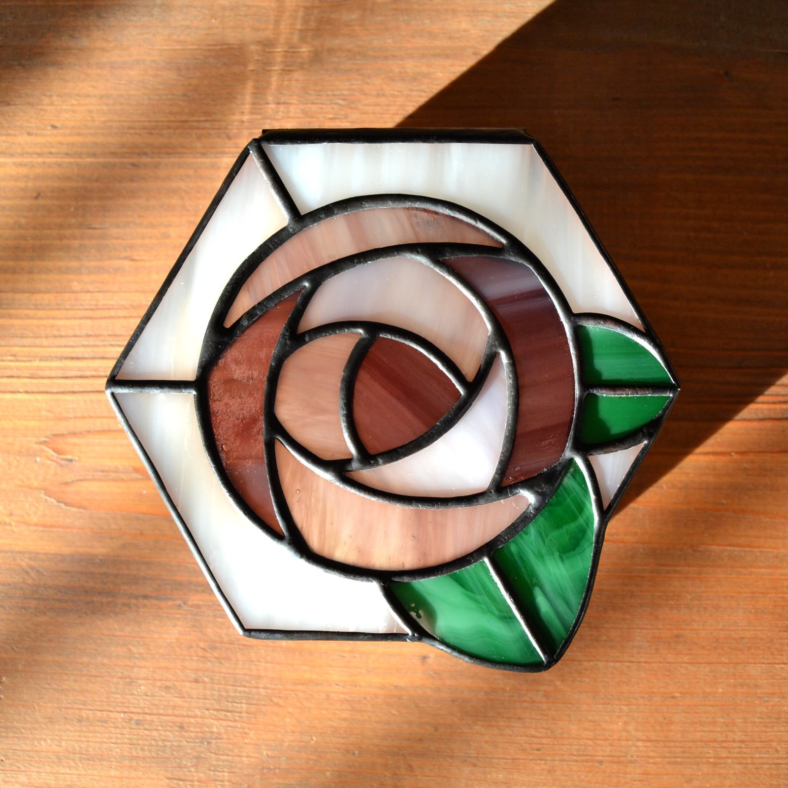 Una caja de vidrio meticulosamente tallada con detalles intrincados que representan una exquisita flor en pleno florecimiento, capturando la belleza y la fragilidad de la naturaleza en una obra de arte transparente.