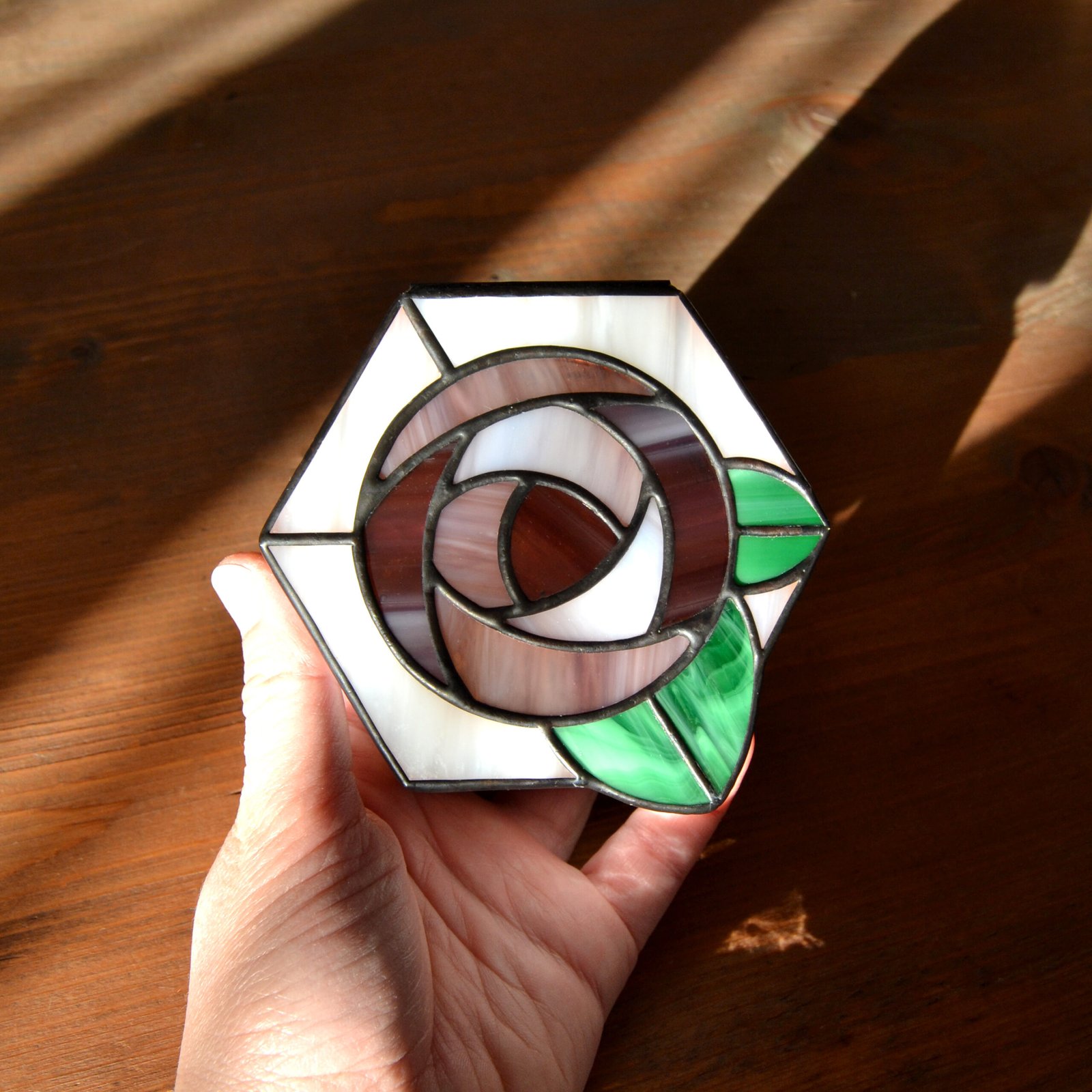 Una caja de vidrio meticulosamente tallada con detalles intrincados que representan una exquisita flor en pleno florecimiento, capturando la belleza y la fragilidad de la naturaleza en una obra de arte transparente.