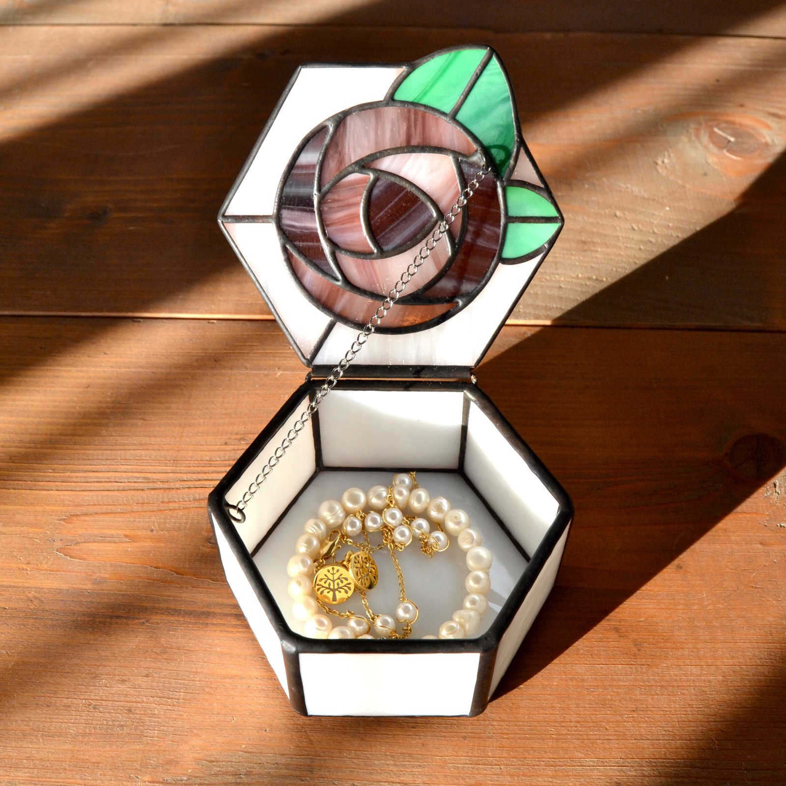 Una caja de vidrio meticulosamente tallada con detalles intrincados que representan una exquisita flor en pleno florecimiento, capturando la belleza y la fragilidad de la naturaleza en una obra de arte transparente.