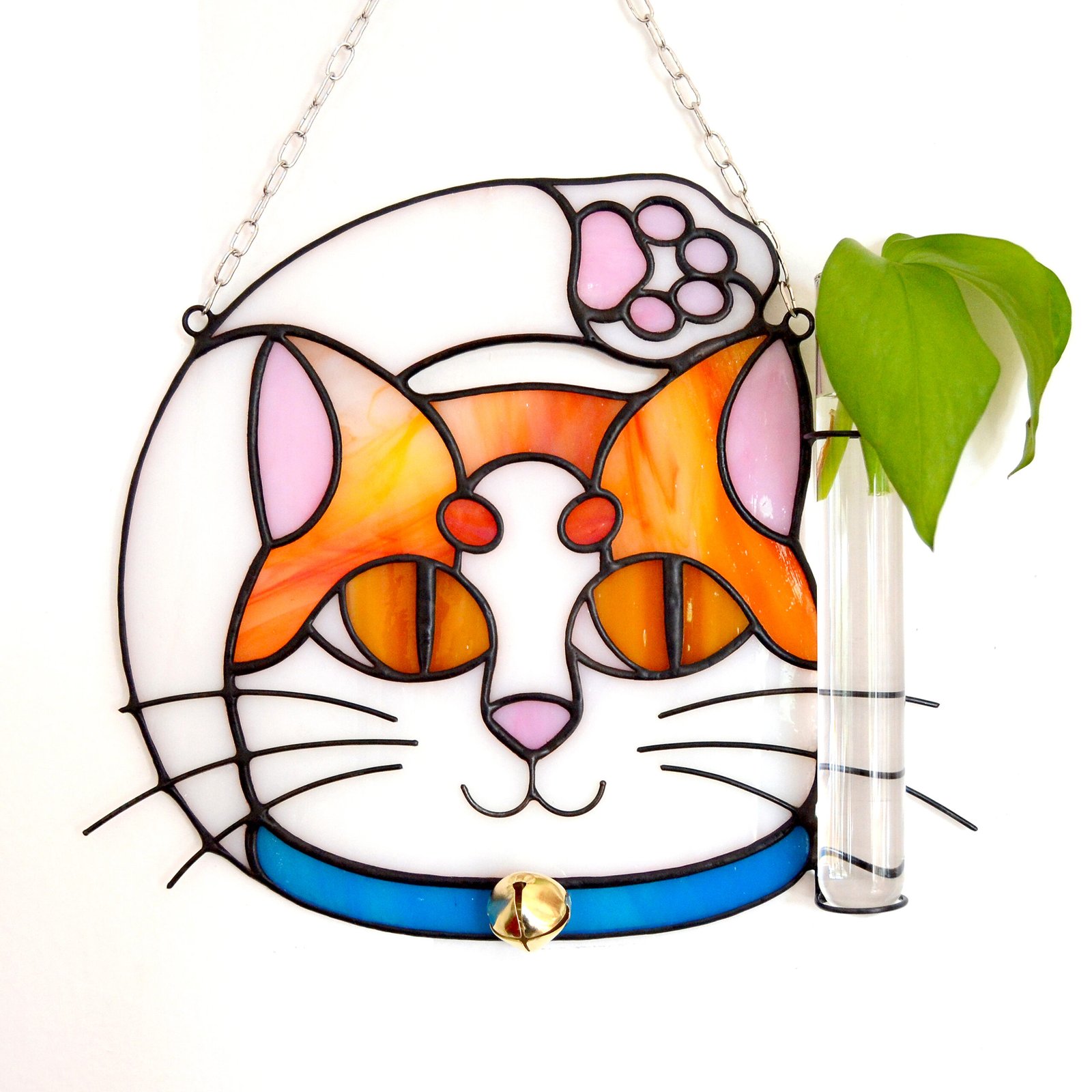 Un vitral que retrata a un elegante gato, con sus ojos curiosos y su pelaje suave y brillante, capturando la gracia y la serenidad de este majestuoso animal mientras la luz del sol filtra a través de los colores vibrantes y crea un efecto cautivador en cualquier espacio.