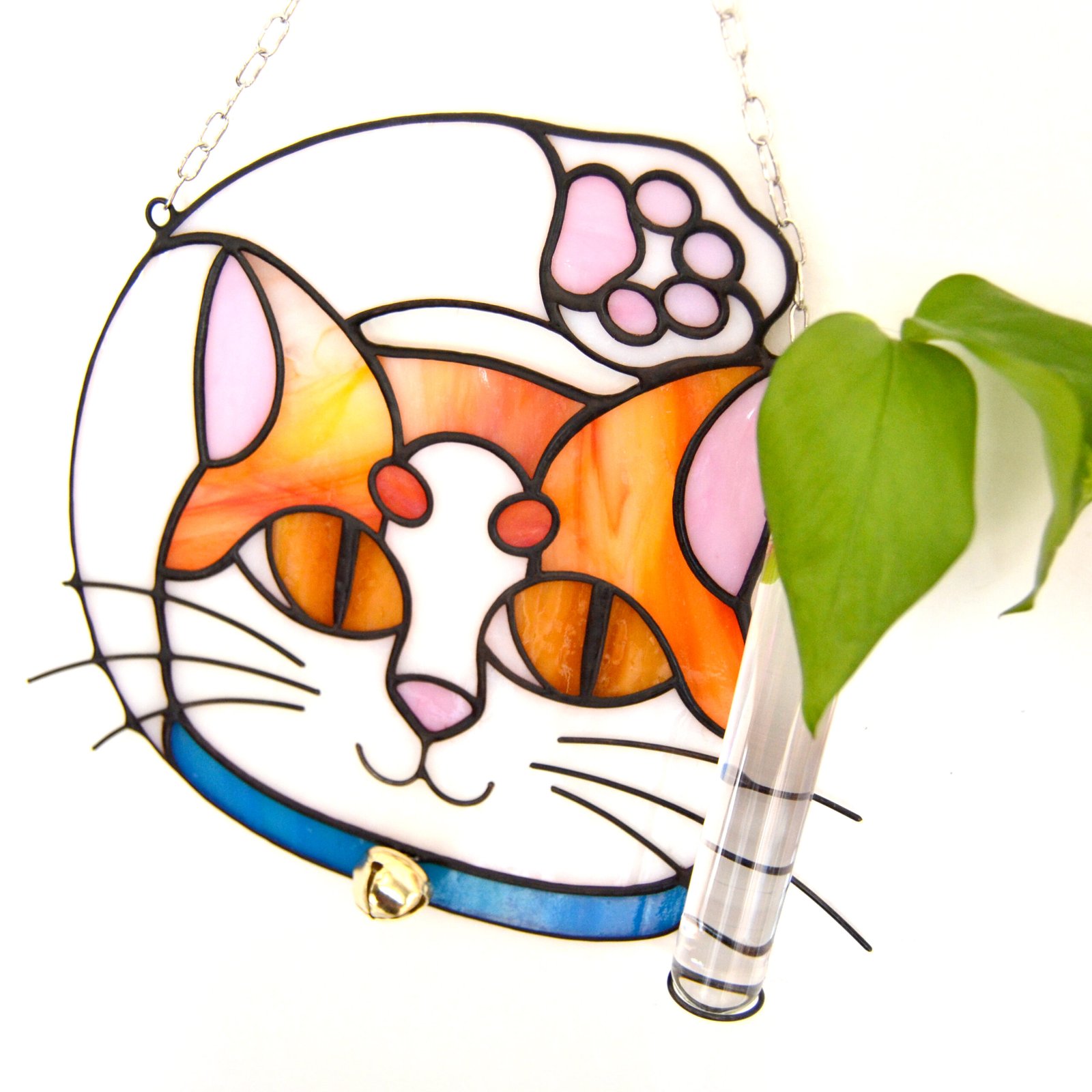 Un vitral que retrata a un elegante gato, con sus ojos curiosos y su pelaje suave y brillante, capturando la gracia y la serenidad de este majestuoso animal mientras la luz del sol filtra a través de los colores vibrantes y crea un efecto cautivador en cualquier espacio.