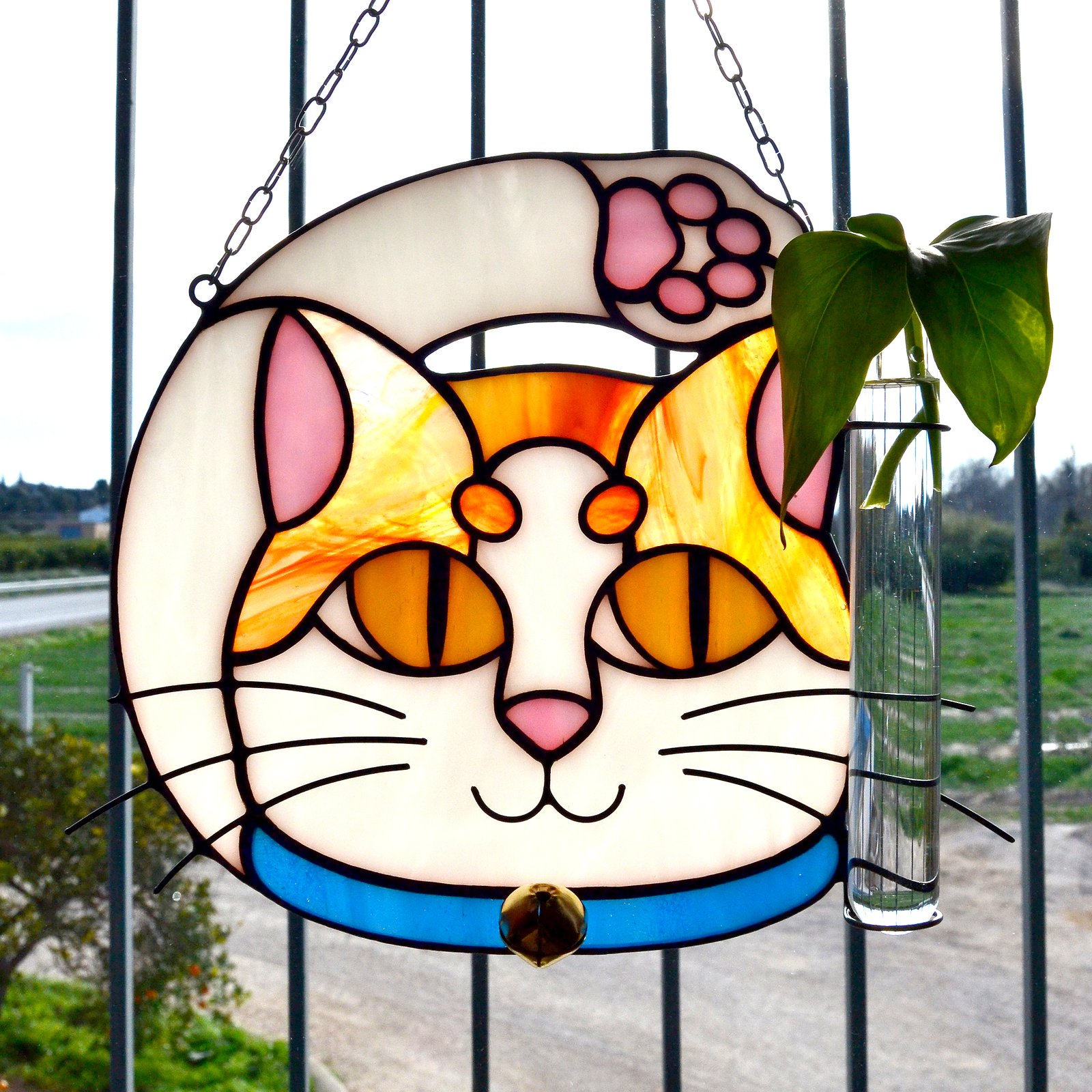 Un vitral que retrata a un elegante gato, con sus ojos curiosos y su pelaje suave y brillante, capturando la gracia y la serenidad de este majestuoso animal mientras la luz del sol filtra a través de los colores vibrantes y crea un efecto cautivador en cualquier espacio.