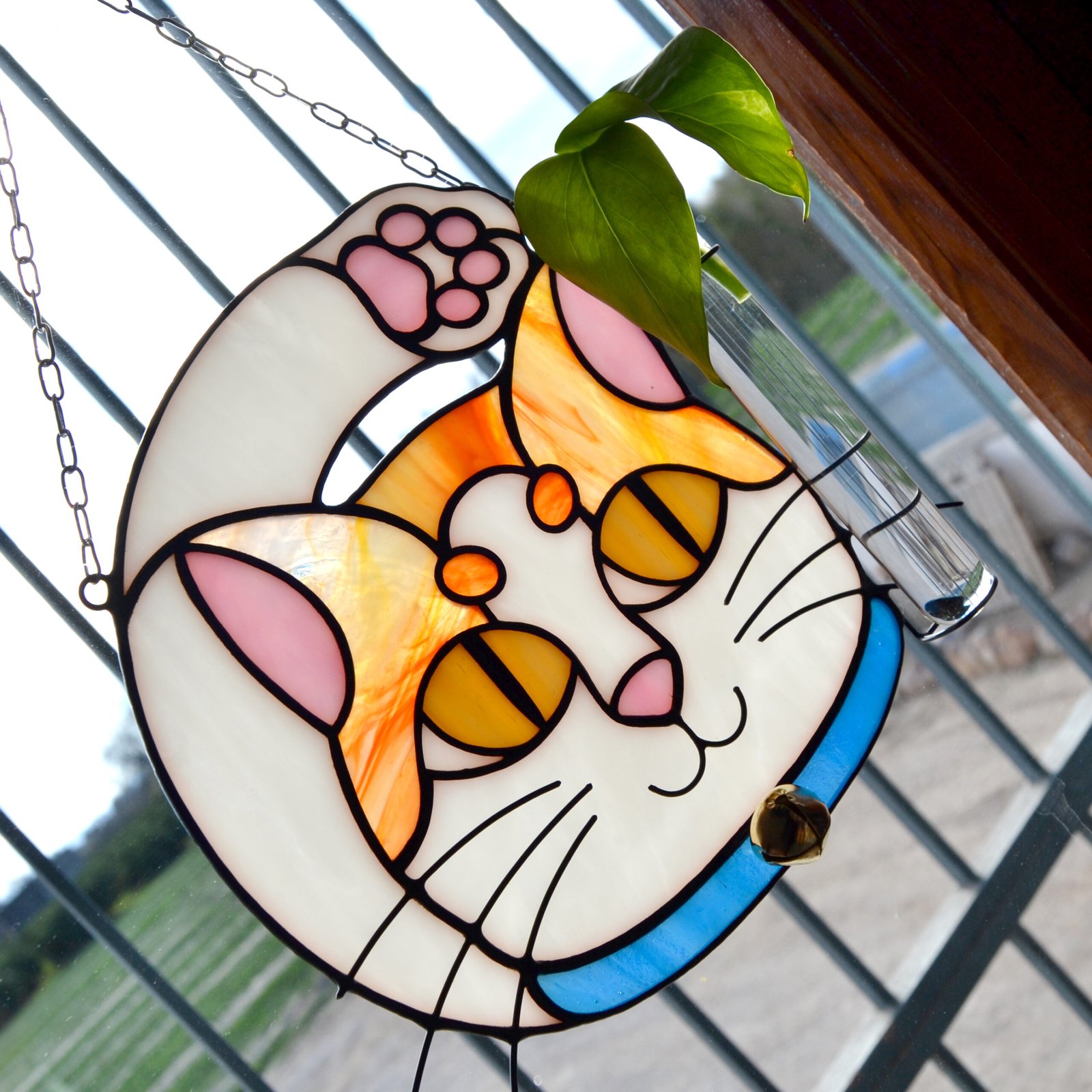 Un vitral que retrata a un elegante gato, con sus ojos curiosos y su pelaje suave y brillante, capturando la gracia y la serenidad de este majestuoso animal mientras la luz del sol filtra a través de los colores vibrantes y crea un efecto cautivador en cualquier espacio.