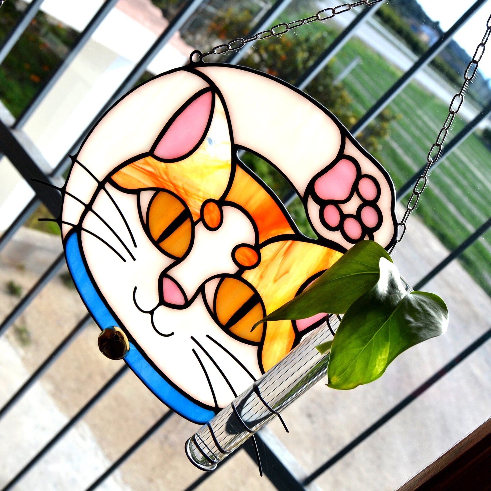 Un vitral que retrata a un elegante gato, con sus ojos curiosos y su pelaje suave y brillante, capturando la gracia y la serenidad de este majestuoso animal mientras la luz del sol filtra a través de los colores vibrantes y crea un efecto cautivador en cualquier espacio.