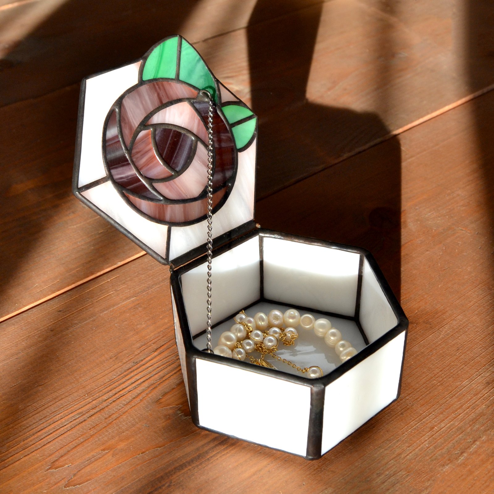 Imagen de una planta decorativa con detalles de vidrio que se entrelazan entre sus hojas, reflejando la luz con delicadeza y añadiendo un toque de brillo y sofisticación a cualquier espacio.