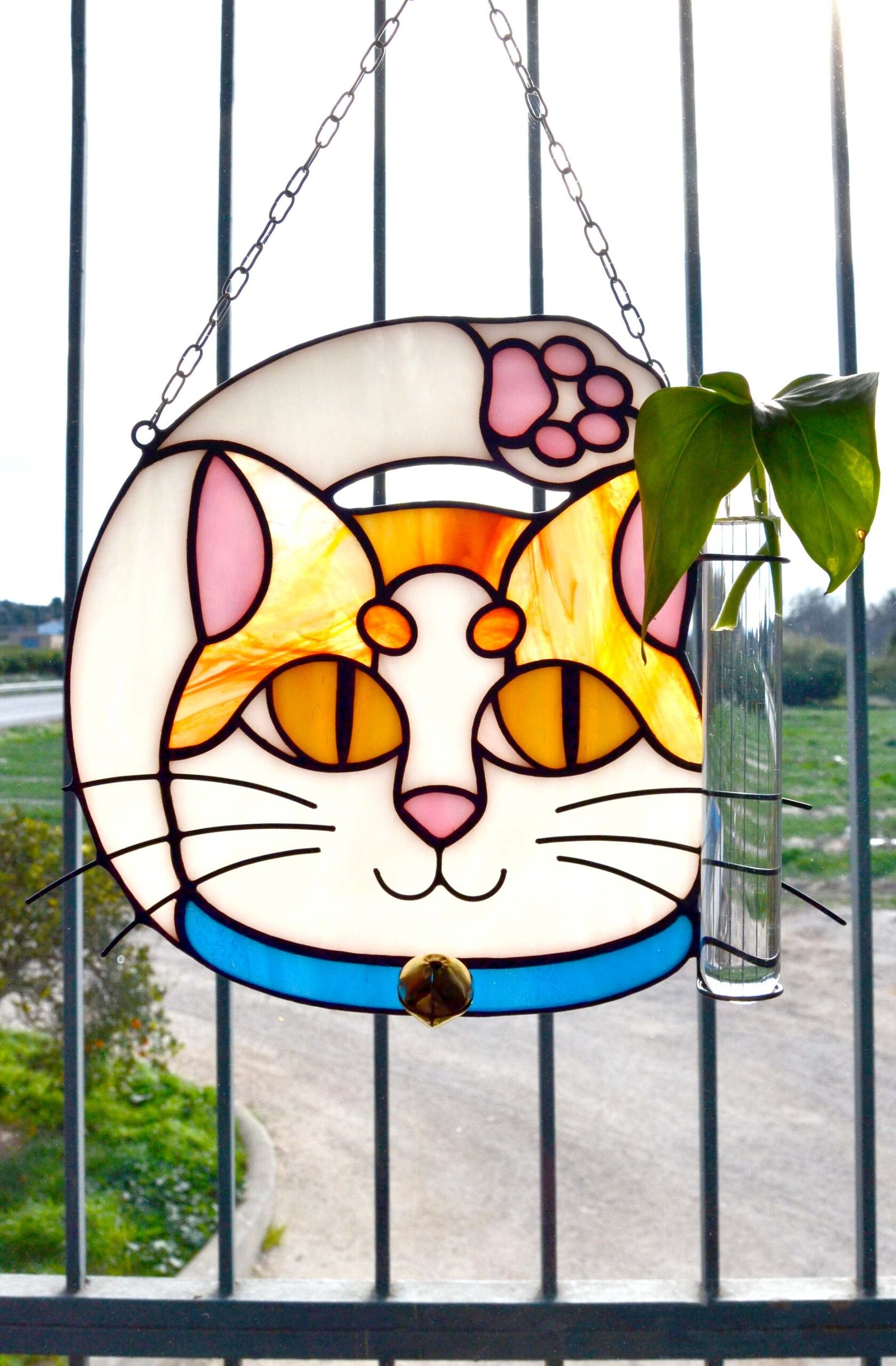 Un vitral que retrata a un elegante gato, con sus ojos curiosos y su pelaje suave y brillante, capturando la gracia y la serenidad de este majestuoso animal mientras la luz del sol filtra a través de los colores vibrantes y crea un efecto cautivador en cualquier espacio.