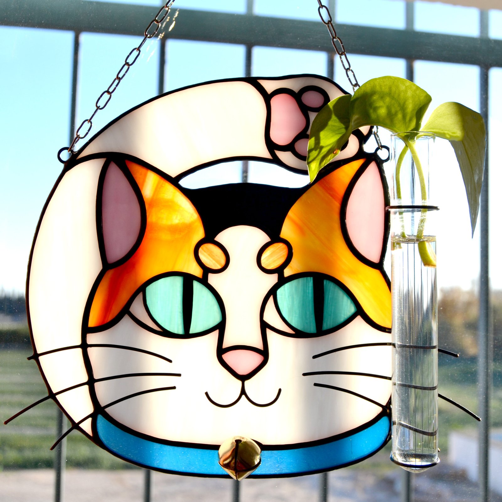 Un vitral que retrata a un elegante gato, con sus ojos curiosos y su pelaje suave y brillante, capturando la gracia y la serenidad de este majestuoso animal mientras la luz del sol filtra a través de los colores vibrantes y crea un efecto cautivador en cualquier espacio.