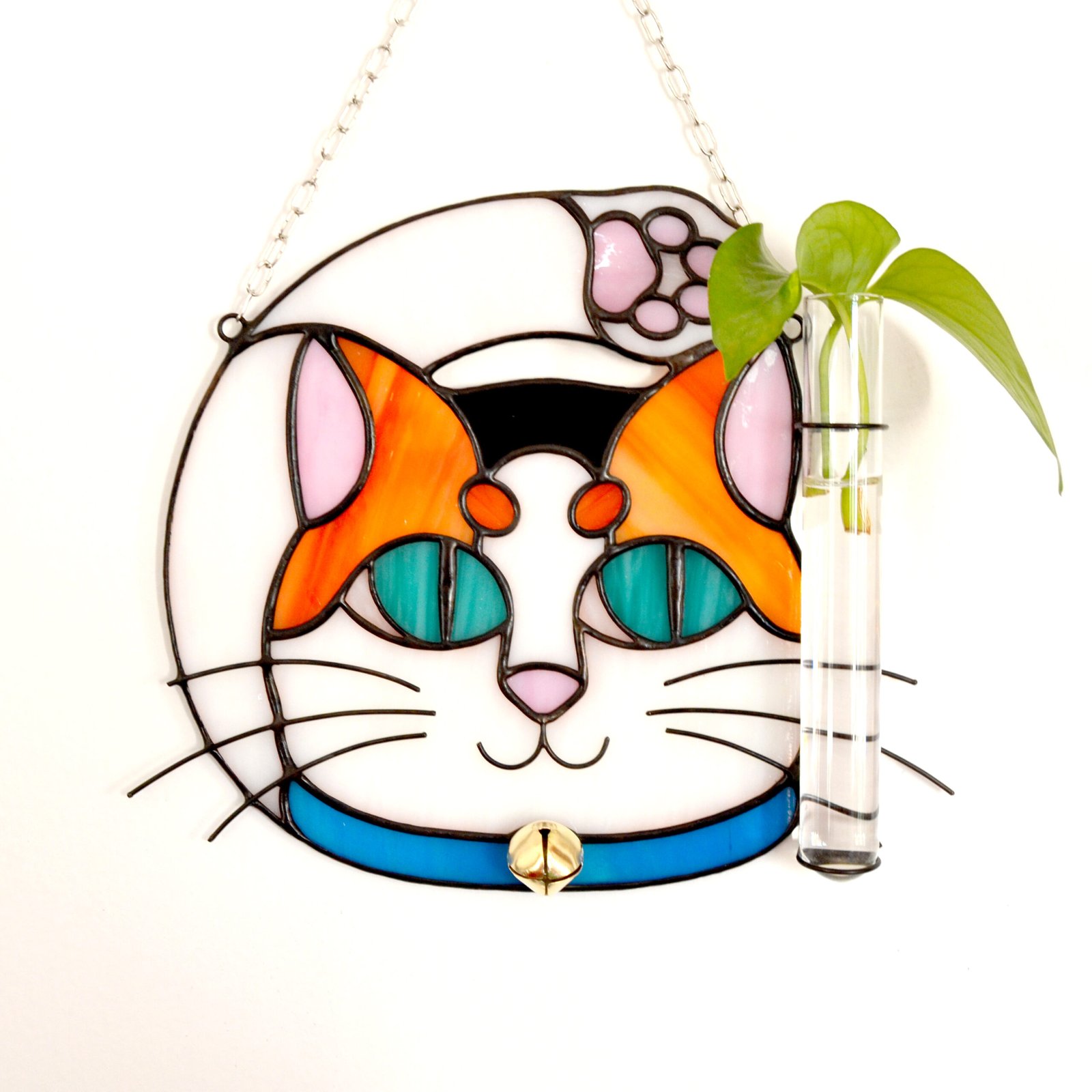 Un vitral que retrata a un elegante gato, con sus ojos curiosos y su pelaje suave y brillante, capturando la gracia y la serenidad de este majestuoso animal mientras la luz del sol filtra a través de los colores vibrantes y crea un efecto cautivador en cualquier espacio.