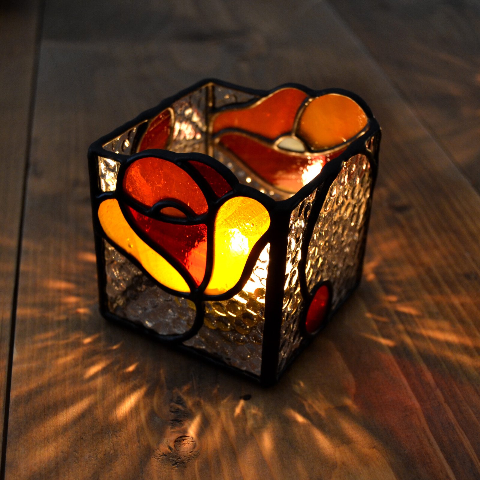 Un bote de vidrio transparente diseñado para sostener una vela, con una estructura resistente y una superficie lisa que permite que la luz de la llama brille con claridad, creando una atmósfera cálida y acogedora en cualquier ambiente.