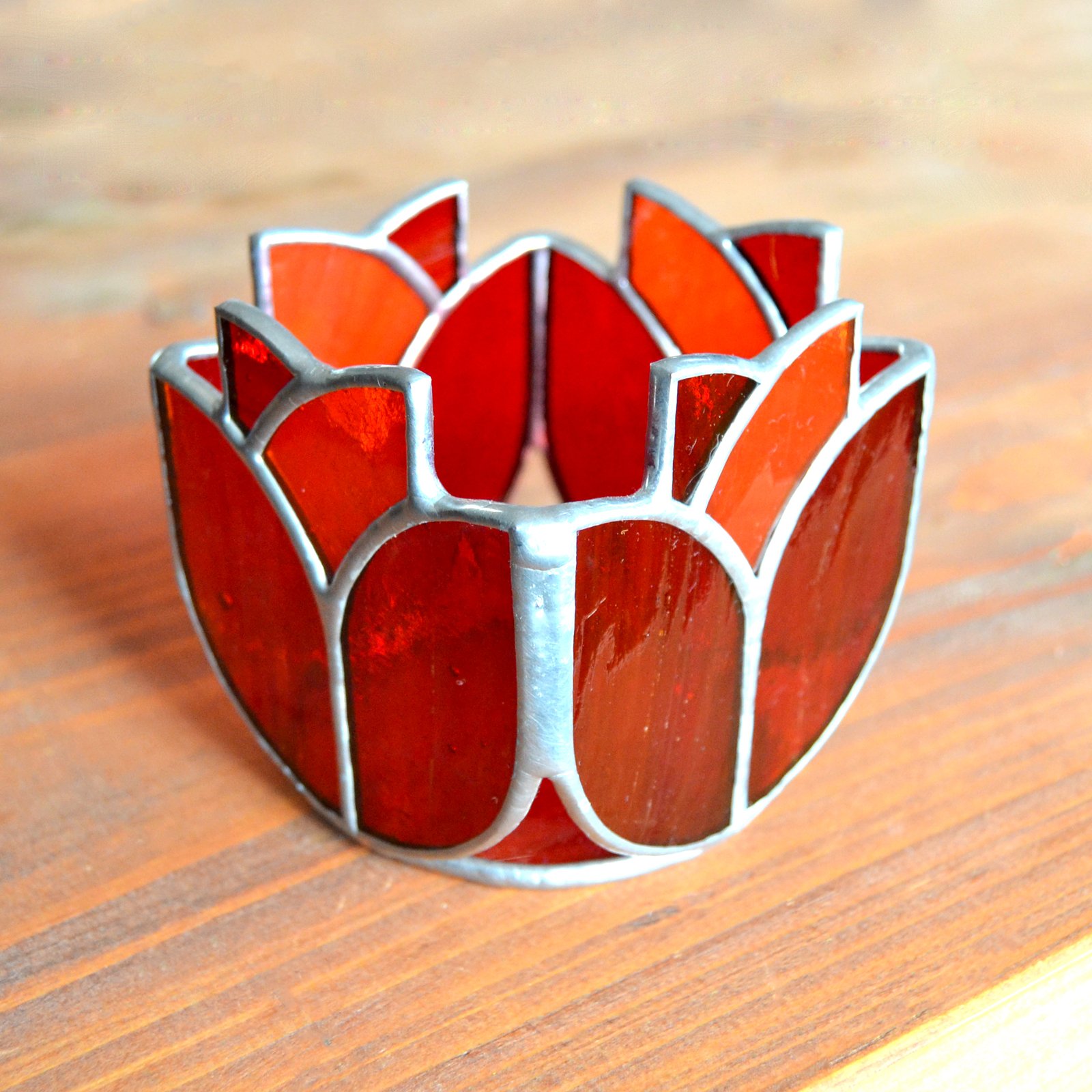 Un bote de vidrio transparente diseñado para sostener una vela, con una estructura resistente y una superficie lisa que permite que la luz de la llama brille con claridad, creando una atmósfera cálida y acogedora en cualquier ambiente.